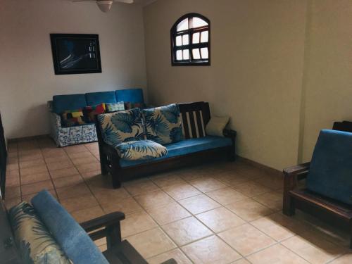 a living room with a blue couch and two chairs at Pousada Ilha Vitoria in Ubatuba
