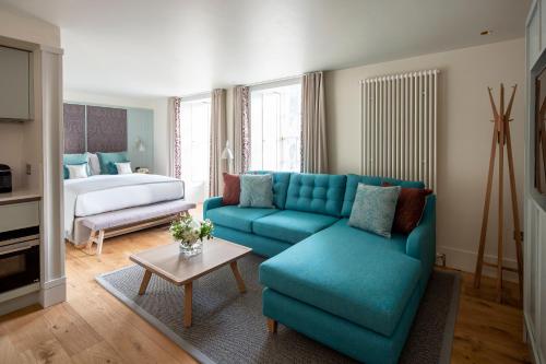 a living room with a blue couch and a bed at Cheval Abbey Strand Apartments, at Holyrood in Edinburgh