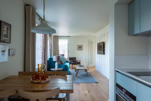a kitchen and living room with a table and chairs at Cheval Abbey Strand Apartments, at Holyrood in Edinburgh