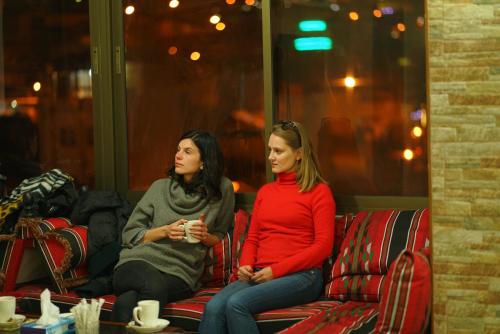 a woman and a man sitting on a red bench at Anbat Midtown Hotel in Wadi Musa
