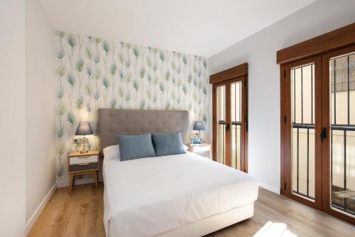 グラナダにあるCielo Granadaの白いベッドと壁が備わるベッドルーム1室が備わります。