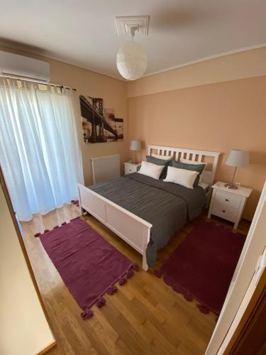una camera con un letto e due tappeti di Nancy's Apartment a Kalamáta