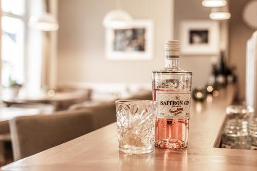 a bottle of whiskey and a glass on a table at Hotel Haberkamp in Achim