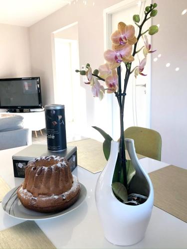 un vase avec des fleurs et un gâteau sur une table dans l'établissement L'escale de la tour, à Breitenbach