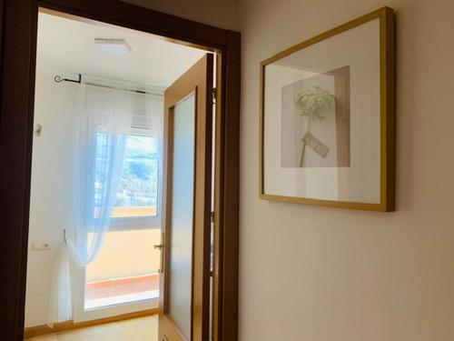 a mirror on a wall with a picture and a window at Aticos La Aliseda by Valdesierra in Béjar