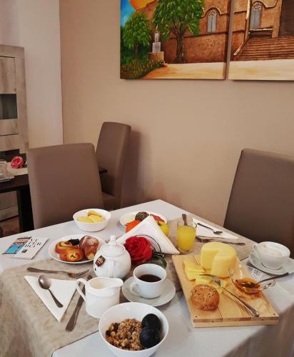 a table with a breakfast of eggs and food on it at Le Undici Rose Hotel in Viterbo