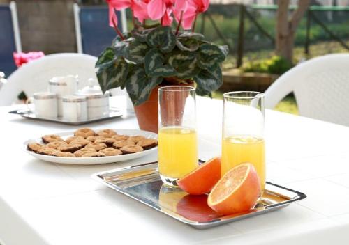 una mesa con dos vasos de zumo de naranja y un plato de comida en Dream House De Iulio, en Pompeya