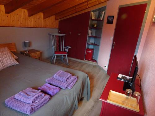 a bedroom with a bed with purple towels on it at la grange à Caroline in Ayent