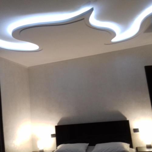 a bedroom with a bed and lights on the ceiling at Makos Guest House in Kutaisi