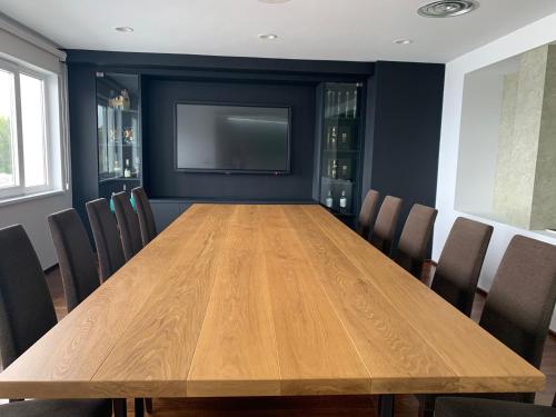 una gran mesa de madera en una habitación con sillas en Hotel Ego en Viveiro