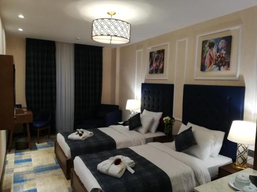 a hotel room with two beds with towels on them at Hyksos Hotel in Erbil