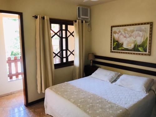 1 dormitorio con cama y ventana en Pousada Praia de Itacoatiara, en Niterói