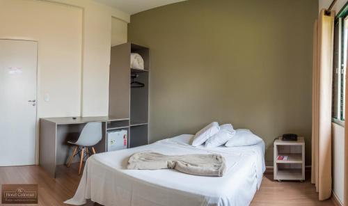 a bedroom with a bed with two towels on it at Colonial Hotel Itatiba in Itatiba