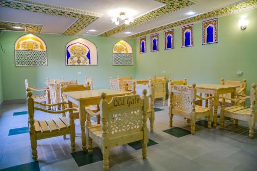 a dining room with tables and chairs and stained glass windows at Old Gate Hotel in Bukhara