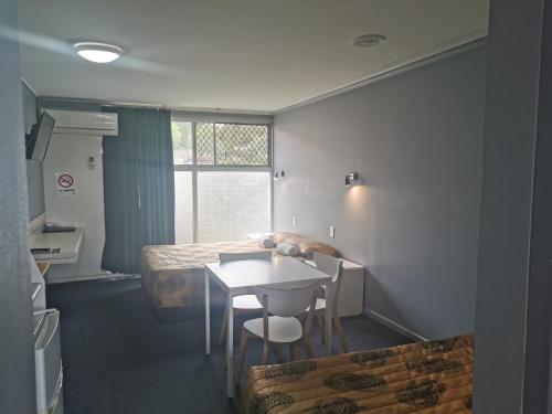 
a kitchen with a table, chairs, and a window at Central Motel Ipswich in Ipswich
