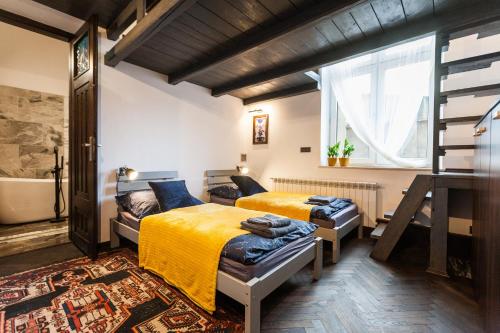 um quarto com 2 camas, uma janela e uma banheira em Stylish Apartment in Krakow Old Town em Cracóvia