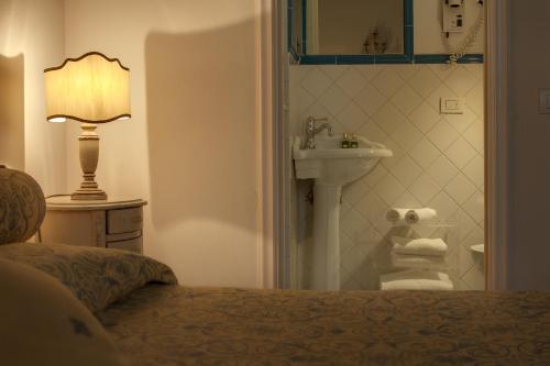 a bathroom with a bed and a sink and a lamp at Florence Dream Domus in Florence