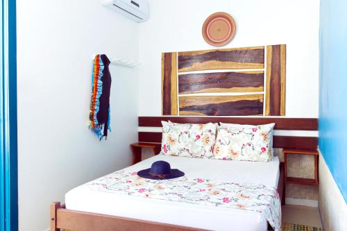 a bedroom with a bed with a hat on it at Pousada Terceiro Espaço in Guaibim