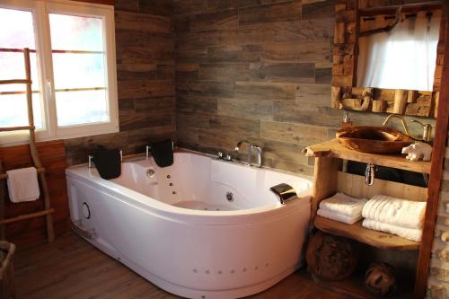 y baño con bañera y paredes de madera. en SWEETS-DREAMS-Amiens-Picardie-insolite-balneo-week-end-amoureux en Contoire