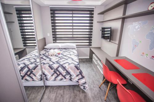 Habitación pequeña con cama y escritorio. en Studio Central prox a Rua XV de Novembro - ALL1311, en Curitiba