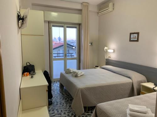 a hotel room with two beds and a window at Hotel Levante Convenzionato Oltremare e Italia in Miniatura in Riccione