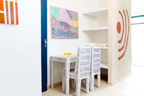 a room with a table and chairs and a shelf at Pousada Terceiro Espaço in Guaibim