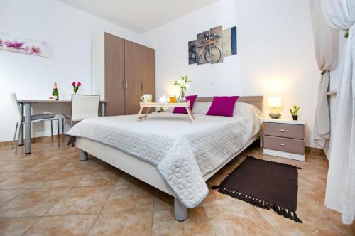 a bedroom with a bed with a table and a desk at F&R Apartments in Rovinj