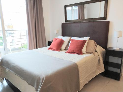 Un dormitorio con una cama grande con almohadas rojas. en Abasto Gardel Tango, en Buenos Aires