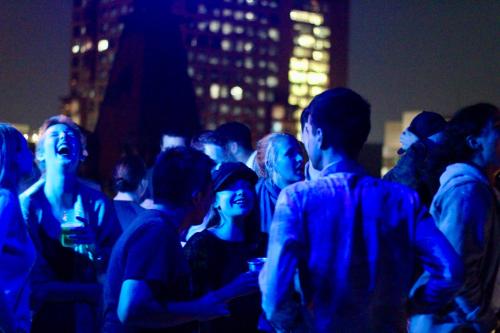 a group of people standing in a crowd at night at Massiosare El Hostal in Mexico City