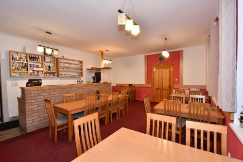 a restaurant with wooden tables and chairs and a bar at Chata Horec in Liptovské Revúce