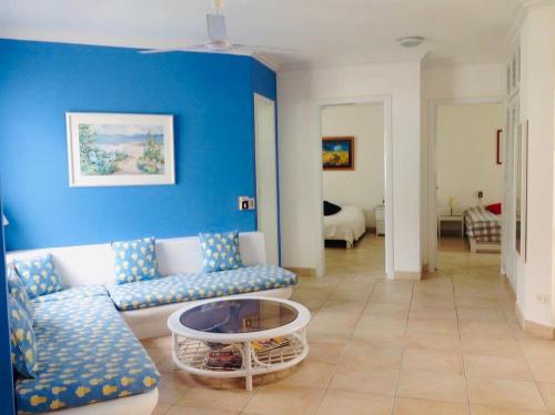 ein Wohnzimmer mit einem Sofa und einem Tisch in der Unterkunft Precioso Dpto a 20 metros de la playa y a pasos de la piscina - Club Casablanca in Same