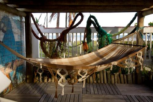 a hammock on a porch with a window at Pousada Terceiro Espaço in Guaibim