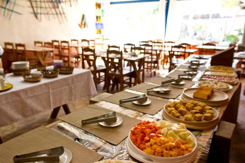 a long table with many plates of food on it at Pousada Terceiro Espaço in Guaibim