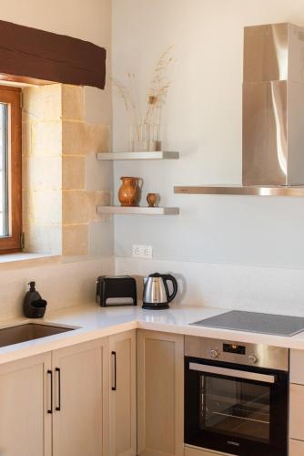 a kitchen with white cabinets and a stove top oven at Prinus Country Retreat Apokoronas, heated pool, 13km from the sea in Embrósneros