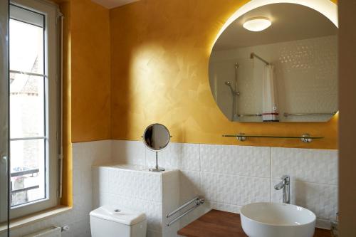 ein Bad mit einem Waschbecken und einem Spiegel in der Unterkunft HOTEL Les Contes de Bruyeres in Servières-le-Château