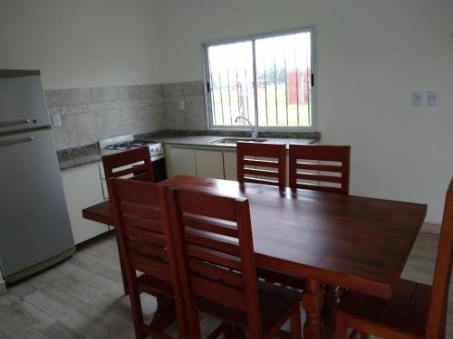 a kitchen with a wooden table and chairs and a sink at Quijaneando in Campo Quijano