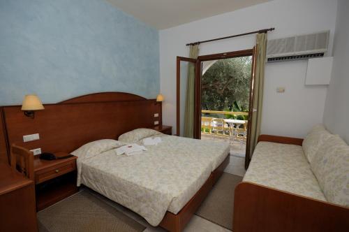 a hotel room with a bed and a window at Hotel Marina Village in Palekastron