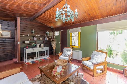 a living room with a chandelier and a fireplace at Hostería El Galpón Del Glaciar in El Calafate