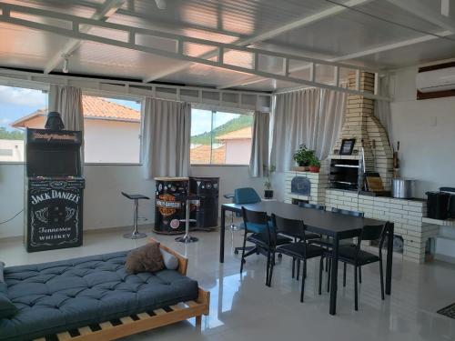 uma sala de estar com um sofá, uma mesa e cadeiras em Cobertura Gourmet á 300mts da praia de Canasvieiras norte da ilha de Floripa em Florianópolis