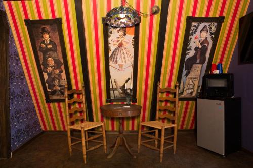 a room with two chairs and a table and some pictures at Hicksville Pines Chalets & Motel in Idyllwild