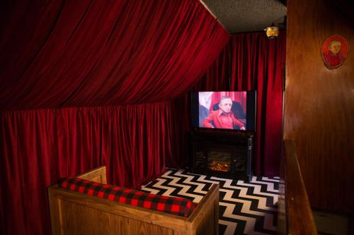 a living room with a tv and red curtains at Hicksville Pines Chalets & Motel in Idyllwild