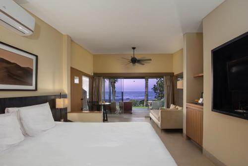 a bedroom with a large bed and a television at Arennas Mancora in Máncora