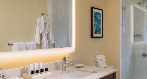 a bathroom with a sink and a mirror and a shower at Grande Colonial La Jolla in San Diego