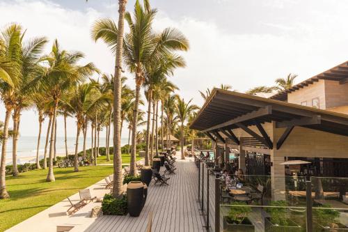 a walkway lined with palm trees next to a building at Arennas Mancora in Máncora