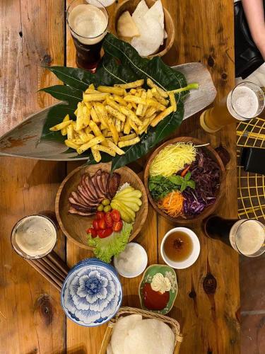 a wooden table with many plates of food on it at Ba Be Green Homestay in Bak Kan