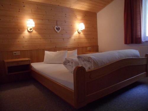 a bedroom with a bed with a wooden wall at Haus Maria in Bach