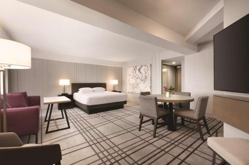a hotel room with a bed and a table and chairs at Hyatt Regency Louisville in Louisville