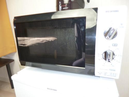 a microwave oven sitting on top of a counter at THE MICKEY CARLTON Ohashi 201 in Shiobaru