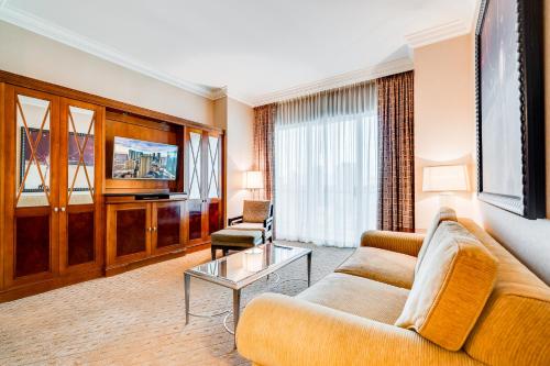a living room with a couch and a tv at Jet Luxury at The Signature Condo Hotel in Las Vegas