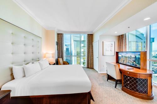 a bedroom with a bed and a desk and a television at Jet Luxury at The Signature Condo Hotel in Las Vegas